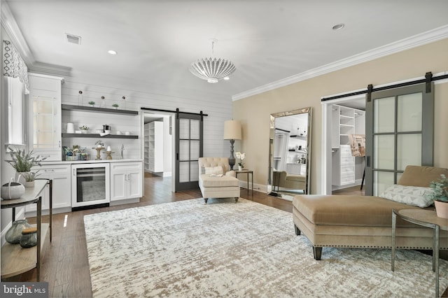 living area with visible vents, ornamental molding, dark wood-type flooring, wine cooler, and a barn door