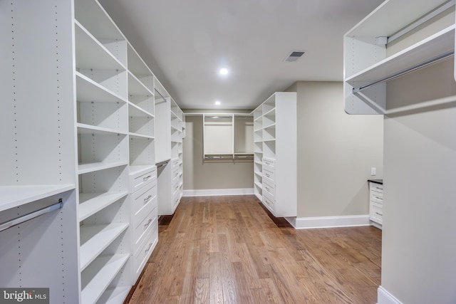 walk in closet with wood finished floors