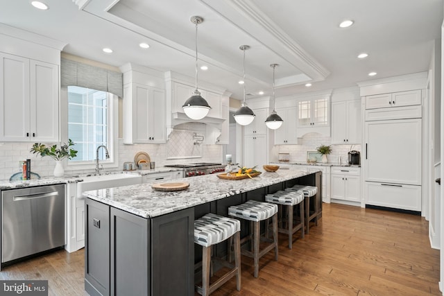 kitchen featuring white cabinetry, a tray ceiling, paneled built in fridge, and stainless steel dishwasher