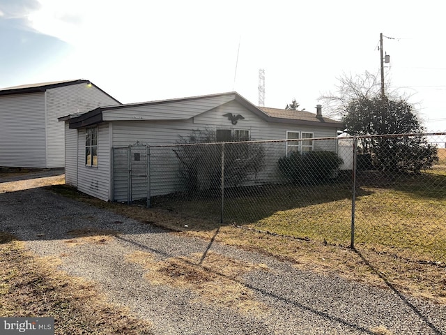 view of side of home featuring fence and a lawn