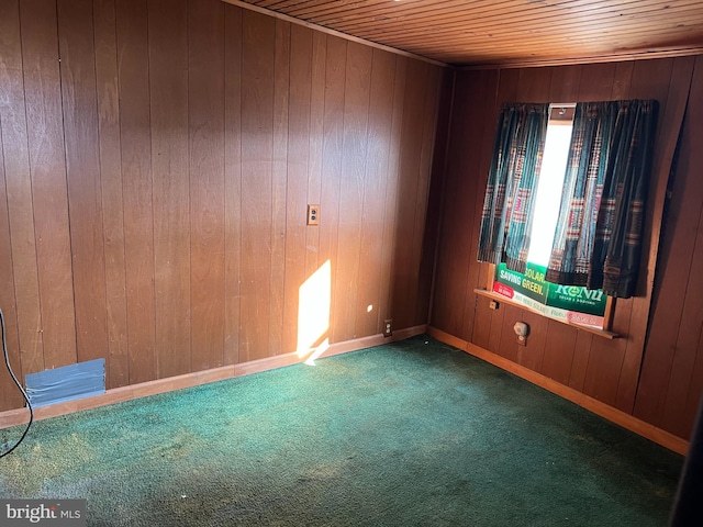 unfurnished room featuring baseboards, carpet floors, wooden walls, and wooden ceiling