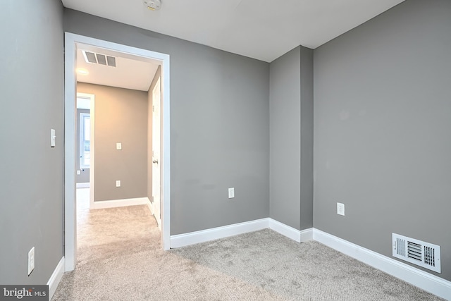 empty room with carpet flooring, baseboards, and visible vents