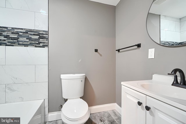 full bathroom featuring vanity, toilet, wood finished floors, and baseboards