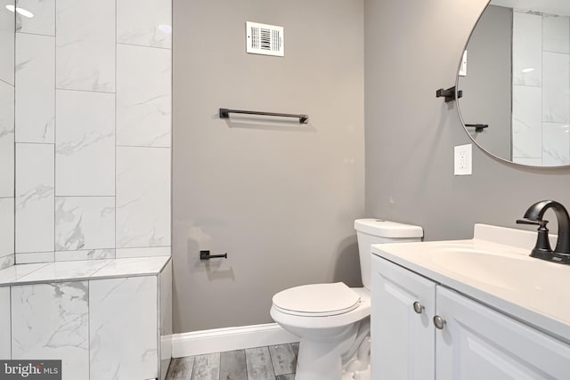 full bathroom featuring visible vents, toilet, wood finished floors, baseboards, and vanity