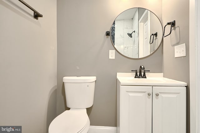 bathroom with toilet, vanity, and baseboards