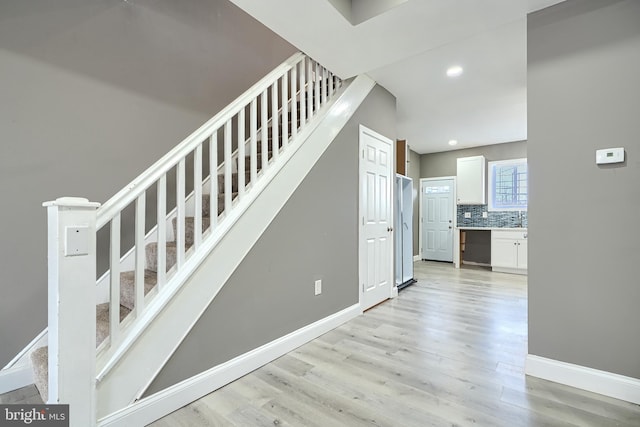 stairs featuring recessed lighting, baseboards, and wood finished floors