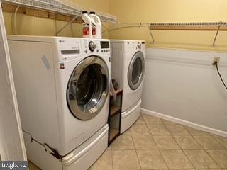 laundry room with light tile patterned floors, independent washer and dryer, and laundry area