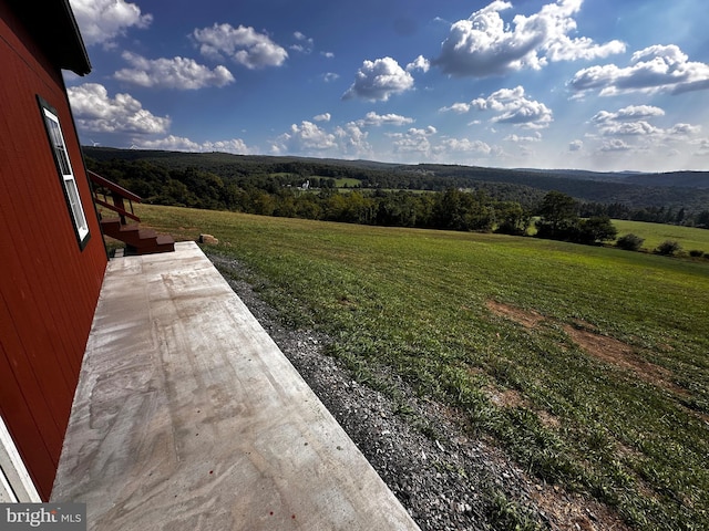 view of yard featuring a rural view and a view of trees