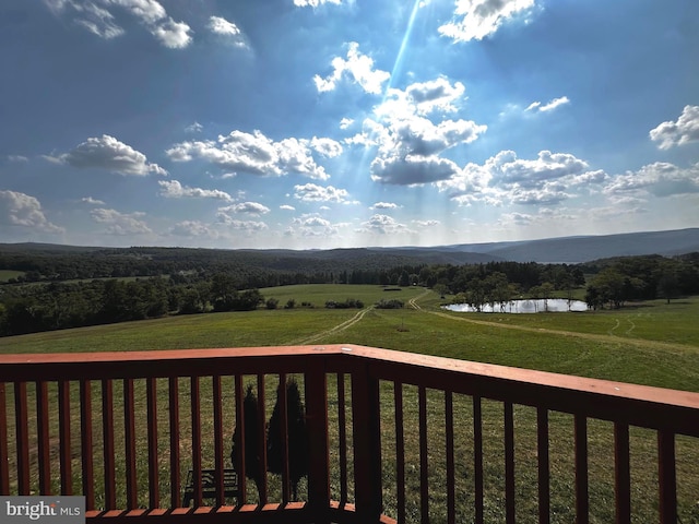 wooden deck with a rural view and a water view