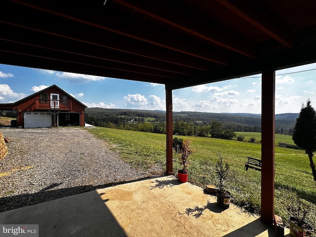 exterior space with a garage, a rural view, and gravel driveway