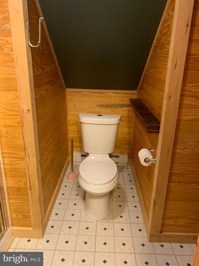 bathroom with baseboard heating, toilet, and wood walls