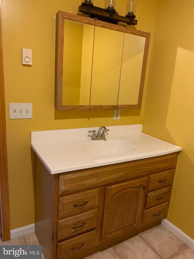 bathroom with vanity, tile patterned floors, and baseboards