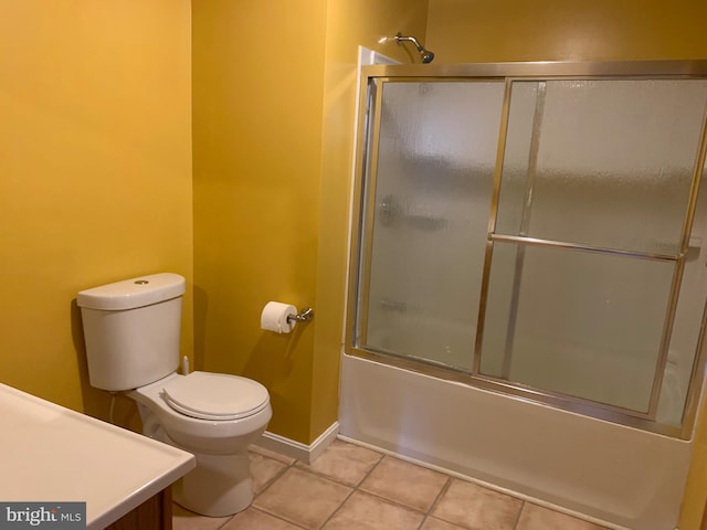 full bath featuring baseboards, toilet, bath / shower combo with glass door, and tile patterned flooring