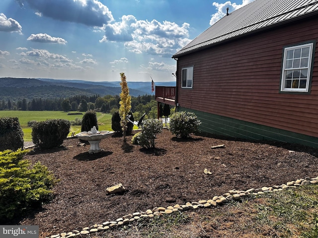 exterior space featuring a standing seam roof, a mountain view, and metal roof