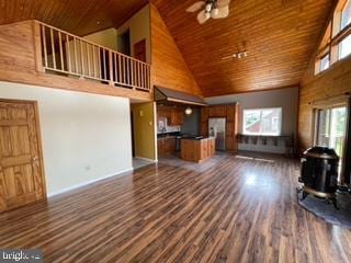 unfurnished living room with a ceiling fan, wood finished floors, high vaulted ceiling, a wood stove, and wooden ceiling