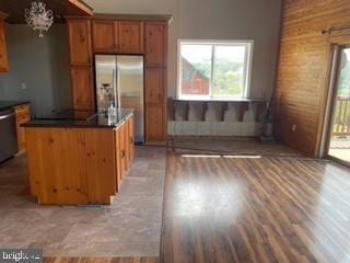 kitchen featuring light wood-type flooring, a notable chandelier, dark countertops, appliances with stainless steel finishes, and brown cabinetry