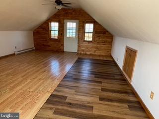 bonus room featuring ceiling fan, lofted ceiling, baseboard heating, and wood finished floors