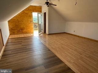 additional living space with baseboards, lofted ceiling, wood finished floors, and a ceiling fan