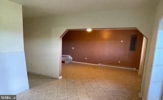 additional living space featuring baseboards and arched walkways