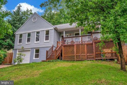 2036 Coast Guard Dr, Stafford, VA 22554 - rear view of property featuring stairs, a yard, an attached garage, and a deck