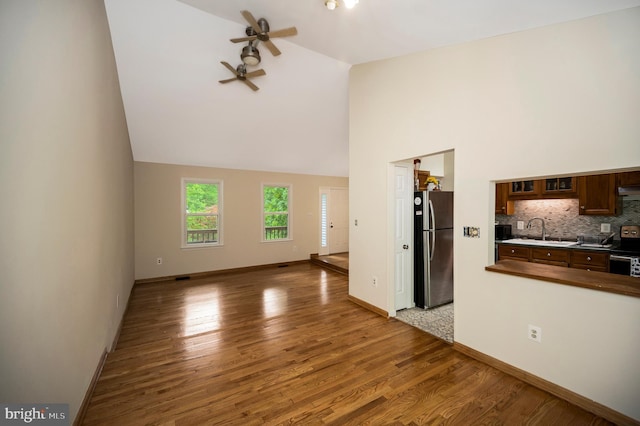 2036 Coast Guard Dr, Stafford, VA 22554 - unfurnished living room with a sink, a ceiling fan, wood finished floors, baseboards, and high vaulted ceiling