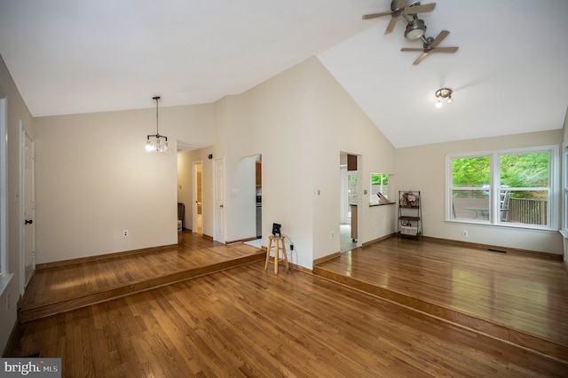 2036 Coast Guard Dr, Stafford, VA 22554 - unfurnished living room with a ceiling fan, wood finished floors, high vaulted ceiling, a chandelier, and baseboards