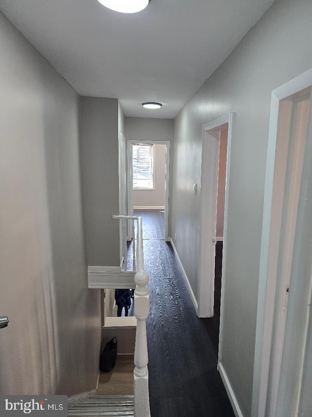 corridor featuring baseboards and an upstairs landing