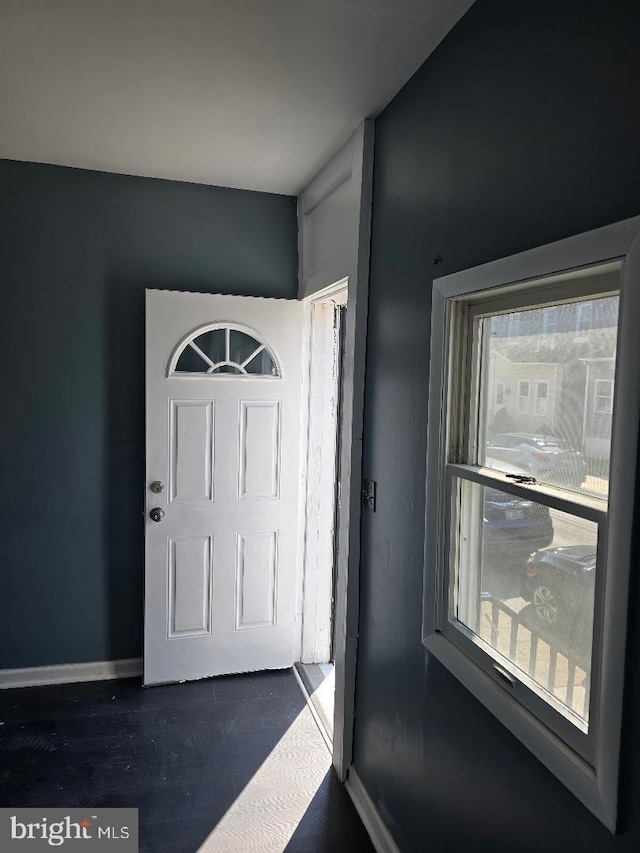 interior space featuring dark wood-style floors, a healthy amount of sunlight, and baseboards