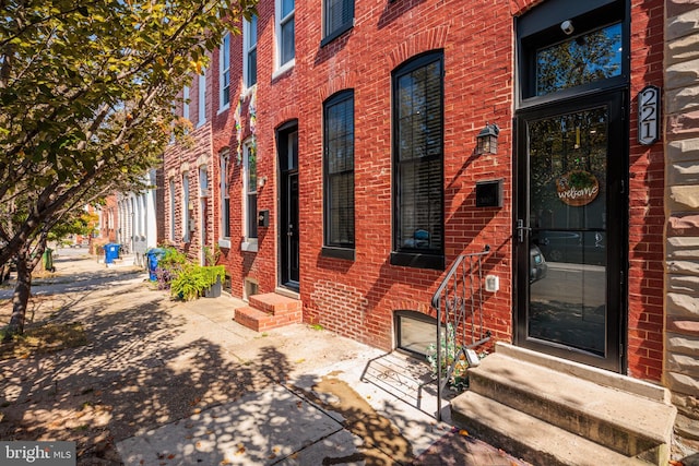 entrance to property featuring brick siding