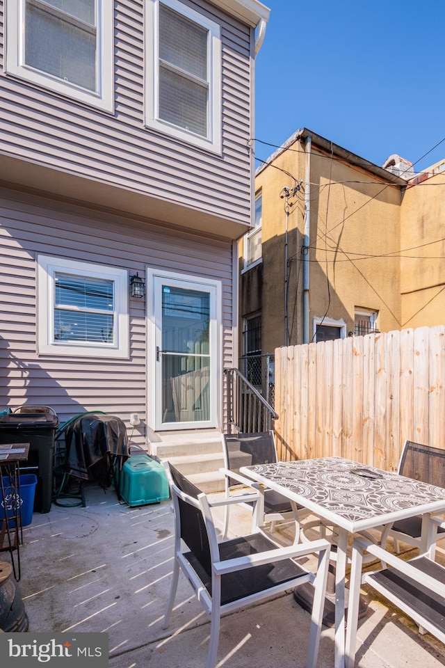 view of patio / terrace featuring fence, a grill, outdoor dining space, and entry steps