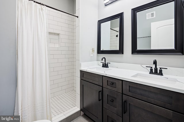 bathroom featuring double vanity, visible vents, a stall shower, and a sink