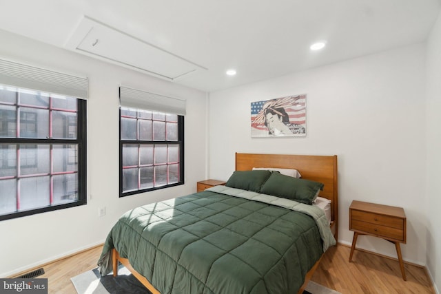 bedroom with visible vents, wood finished floors, recessed lighting, baseboards, and attic access