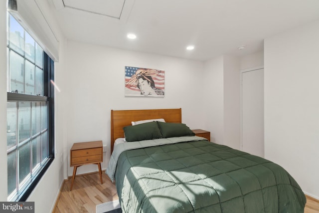 bedroom with recessed lighting, light wood-type flooring, and baseboards