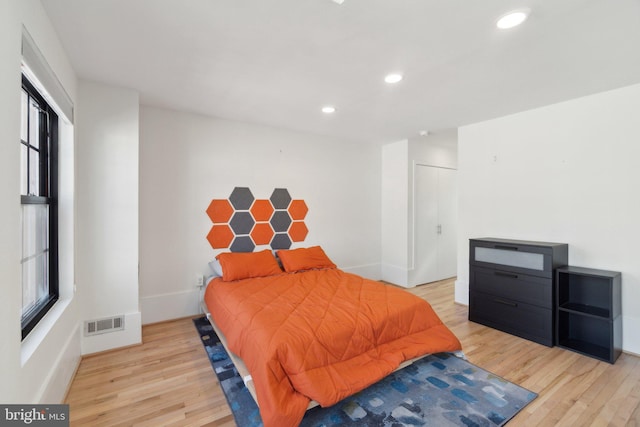 bedroom with recessed lighting, visible vents, light wood finished floors, and baseboards