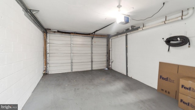 garage featuring a garage door opener and concrete block wall