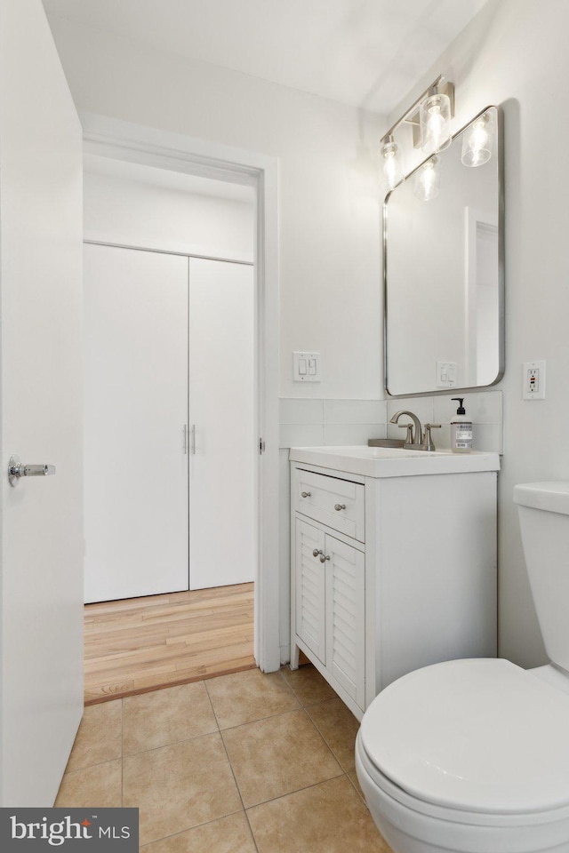 bathroom featuring toilet, vanity, and tile patterned flooring