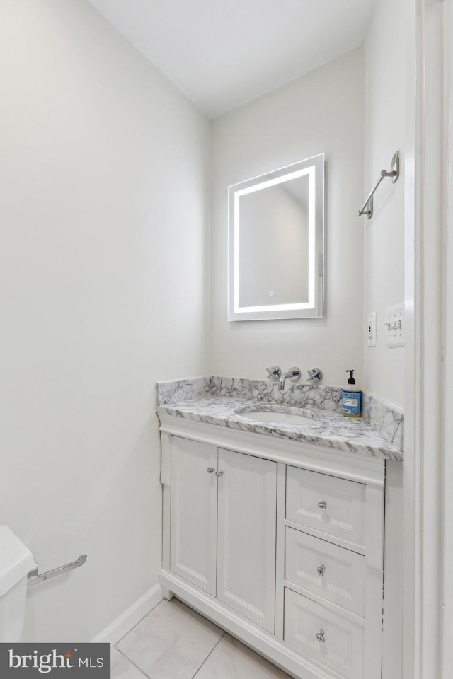 bathroom with baseboards, marble finish floor, and vanity