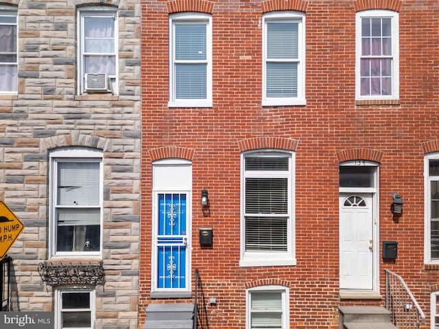 132 N Glover St N, Baltimore, MD 21224 - view of front facade featuring stone siding, entry steps, cooling unit, and brick siding
