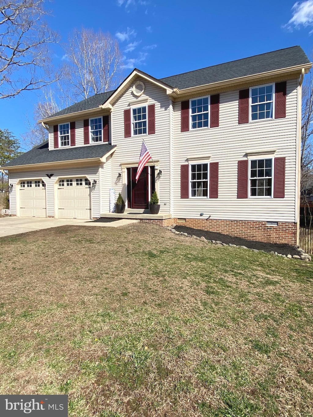 view of front of house with crawl space, an attached garage, concrete driveway, and a front yard