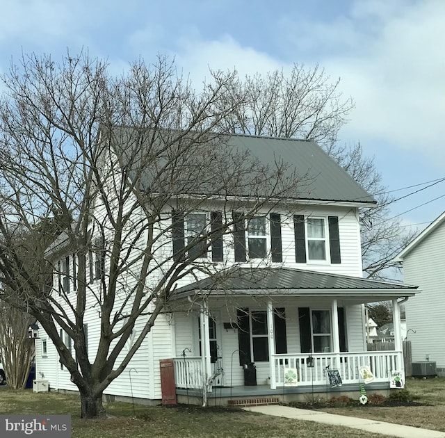 country-style home with covered porch, cooling unit, and metal roof