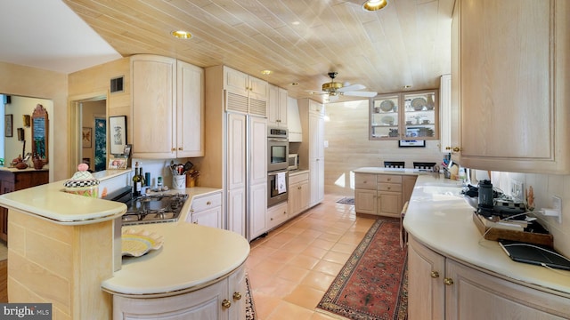 kitchen with a peninsula, light brown cabinets, and light countertops