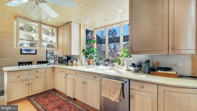 kitchen featuring stainless steel dishwasher, a ceiling fan, a sink, and light brown cabinetry