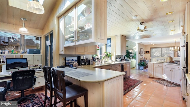 kitchen featuring a peninsula, ceiling fan, light countertops, wood ceiling, and decorative light fixtures