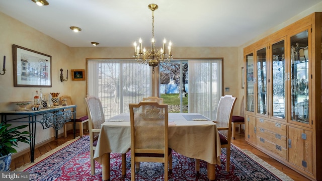 dining area featuring baseboards, a notable chandelier, and wood finished floors