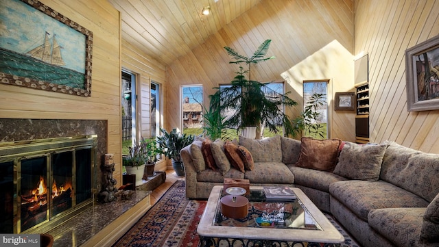 living room with wooden walls, high vaulted ceiling, wooden ceiling, and a high end fireplace