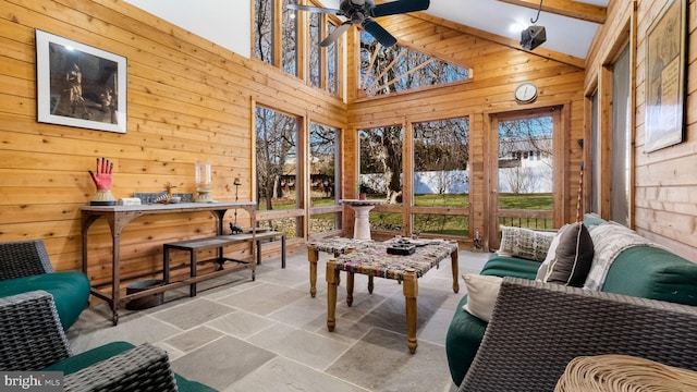 sunroom with lofted ceiling with beams and a ceiling fan