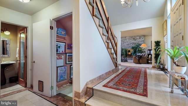 entrance foyer with tile patterned flooring, stairway, and a notable chandelier