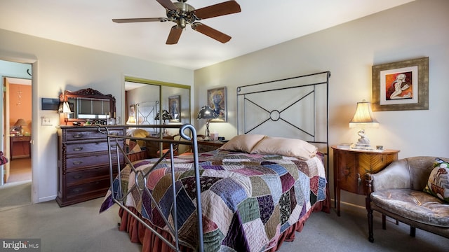 carpeted bedroom with a closet, baseboards, and ceiling fan