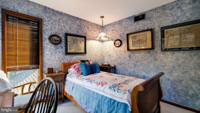 carpeted bedroom featuring visible vents, baseboards, and wallpapered walls