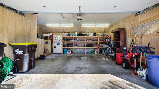 garage featuring wooden walls and a garage door opener